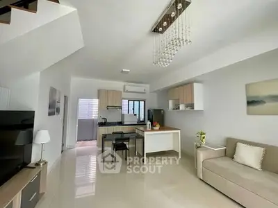 Modern open-plan living room with sleek kitchen and stylish decor, perfect for contemporary living.