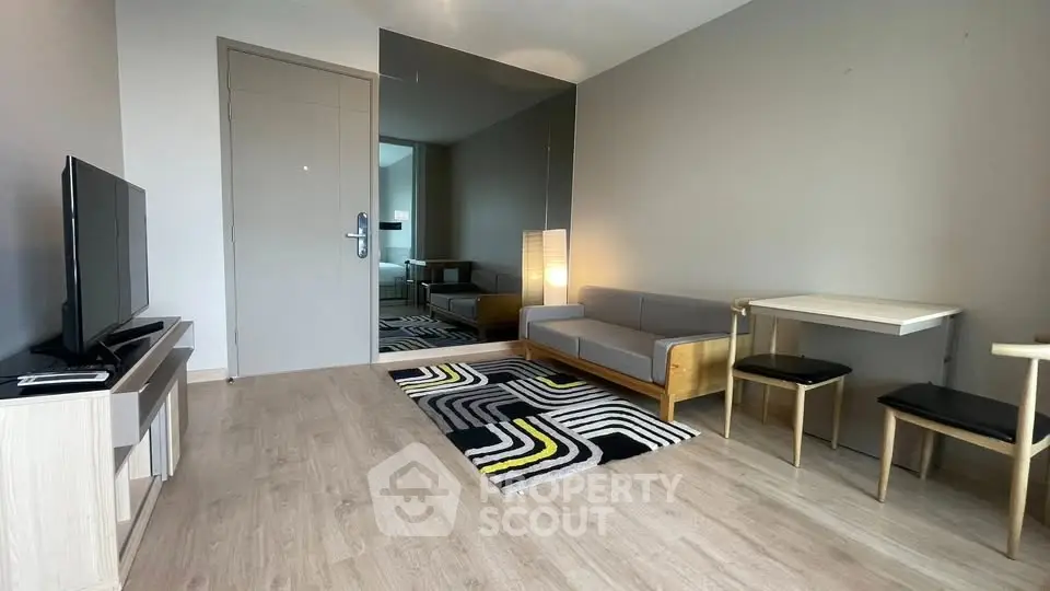 Modern living room with stylish furniture and large mirror enhancing space.