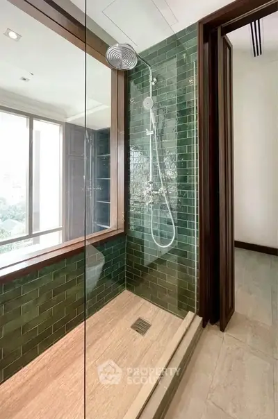 Luxurious bathroom with green tiled shower and large window view
