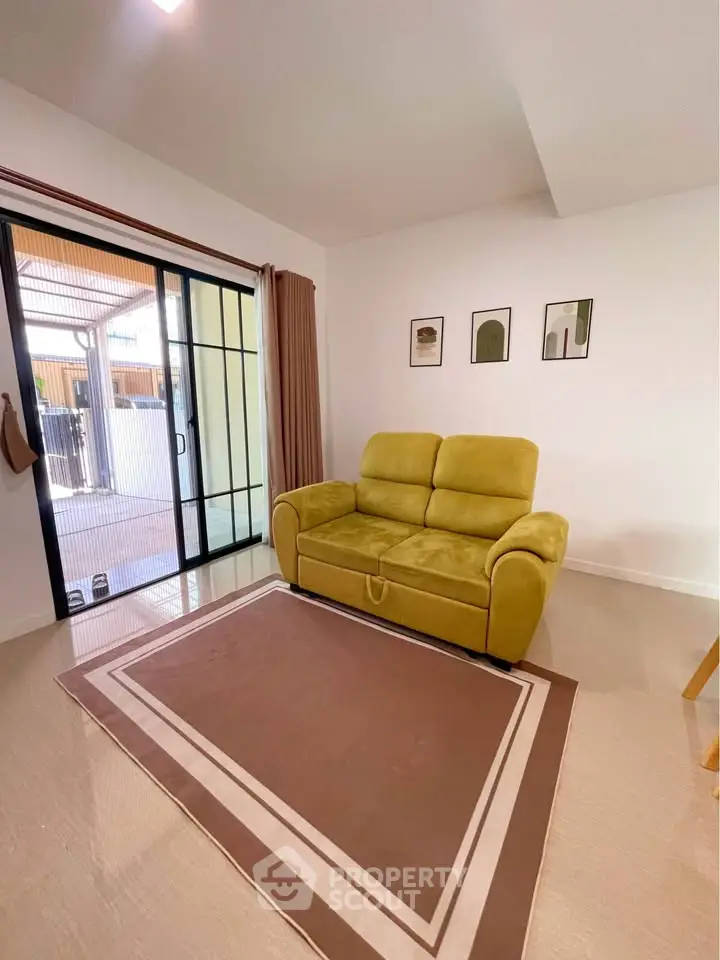 Cozy living room with stylish sofa and sliding glass doors leading to balcony.