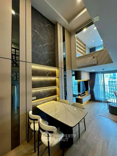 Luxurious modern living room with high ceilings and elegant marble accents in a stylish apartment.