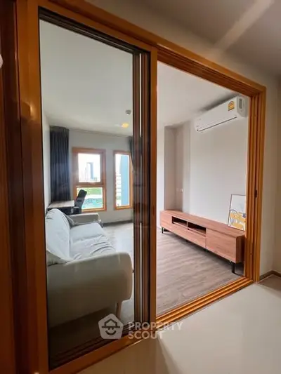 Modern living room with sleek furniture and large windows offering city views.