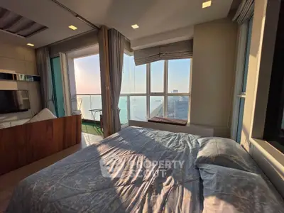 Luxurious bedroom with stunning ocean view and large windows in high-rise apartment