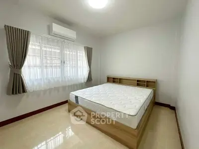 Spacious bedroom with natural light and modern furnishings in a cozy real estate property.