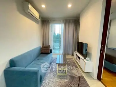 Modern living room with blue sofa, TV, and balcony access in stylish apartment.