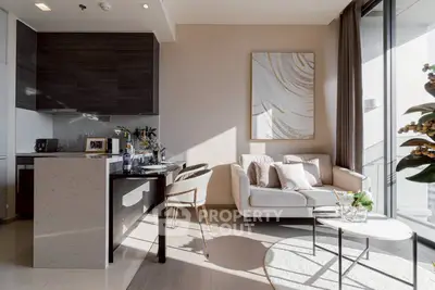 Modern open-layout living room with stylish kitchen and cozy seating area, flooded with natural light.