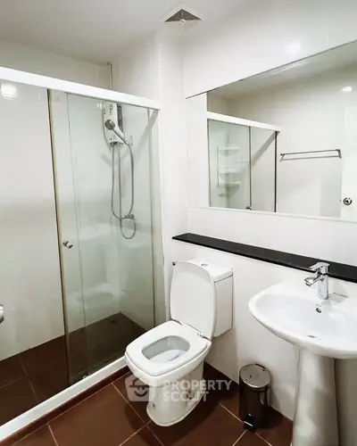 Modern bathroom with glass shower and sleek fixtures in a contemporary home.