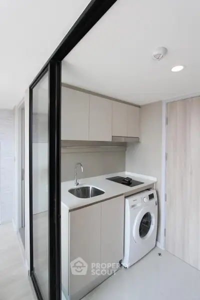 Modern compact kitchen with washing machine and sleek design