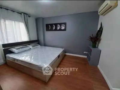 Modern bedroom with stylish decor and air conditioning in a cozy apartment.
