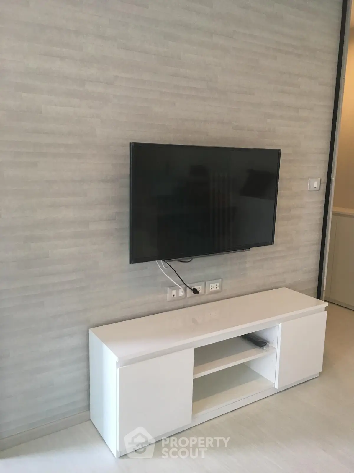 Modern living room with wall-mounted TV and sleek white console
