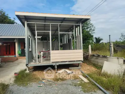 Modern prefab house under construction with metal frame and wooden panels