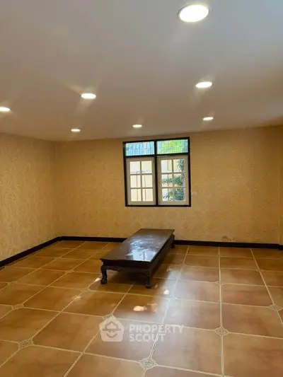 Spacious living room with elegant lighting and large window, perfect for cozy gatherings.
