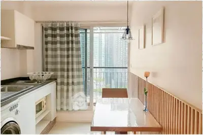 Modern kitchen with balcony view, featuring sleek appliances and stylish decor in a high-rise apartment.