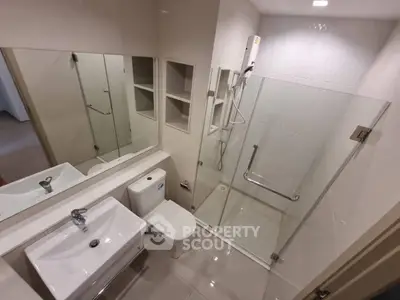 Modern bathroom with glass shower and sleek fixtures in a contemporary apartment.