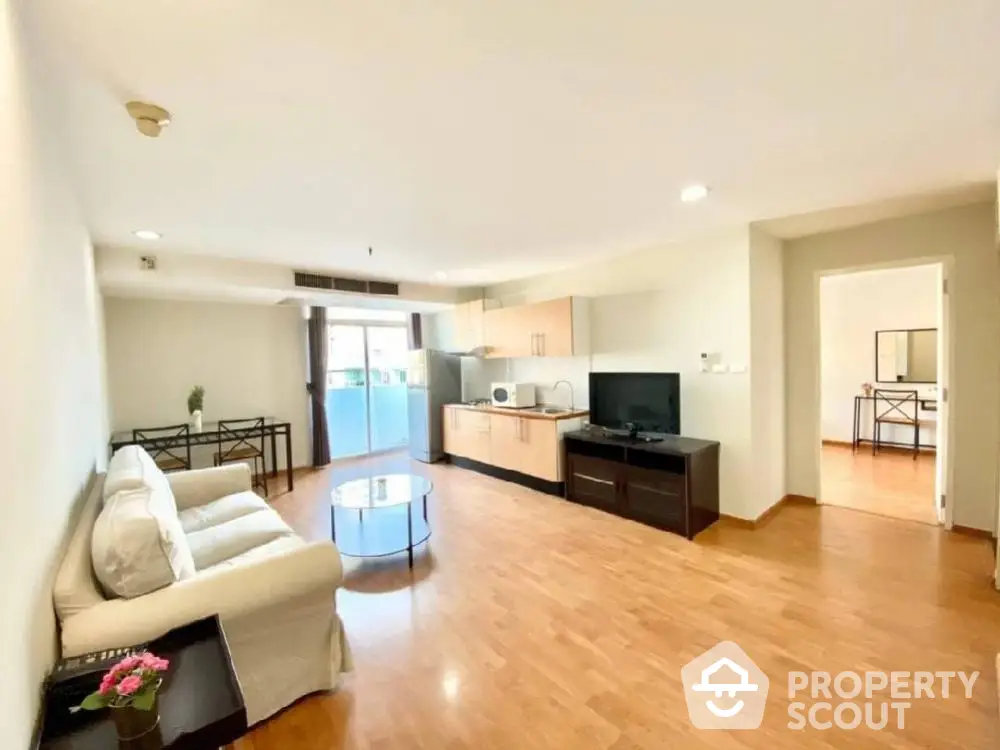 Spacious open-plan living room with modern kitchen and wooden flooring