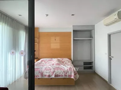 Spacious bedroom with large windows and modern air conditioning unit