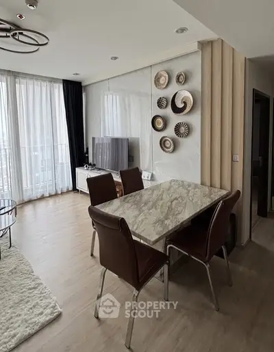 Modern living room with marble dining table and stylish decor in a bright apartment.
