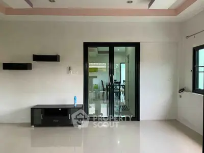 Modern interior with glass sliding doors and sleek furniture in a bright room.