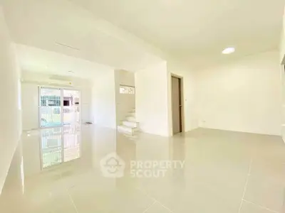 Spacious modern living room with glossy tiled floors and staircase