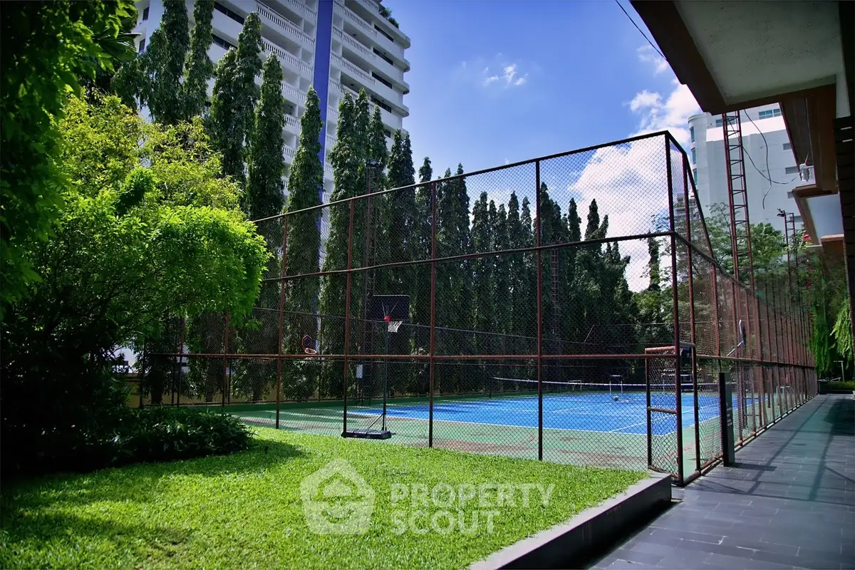 Luxurious residential complex with tennis court and lush greenery