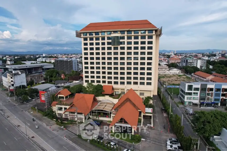 Stunning aerial view of a modern high-rise building with red-tiled roofs in a vibrant urban setting.