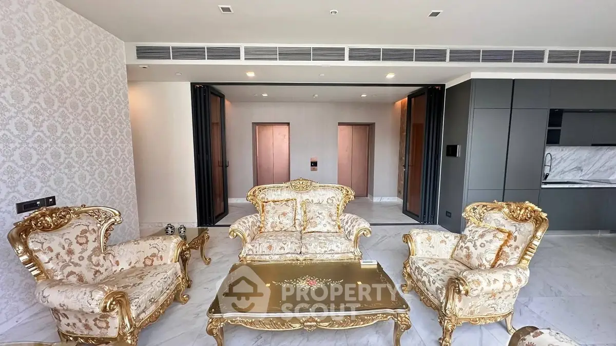 Luxurious living room with ornate gold furniture and modern kitchen, perfect for elegant entertaining.