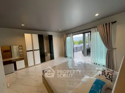 Spacious bedroom with large windows and balcony offering scenic views