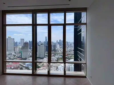 Stunning cityscape view from high-rise apartment with floor-to-ceiling windows.