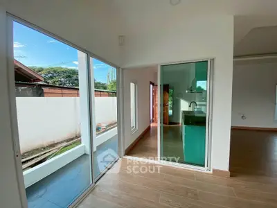 Spacious modern living area with large windows and wooden flooring, perfect for natural light lovers.