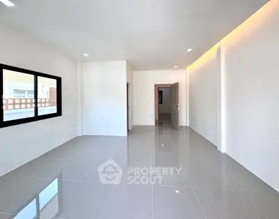 Spacious modern living room with sleek tile flooring and ambient lighting