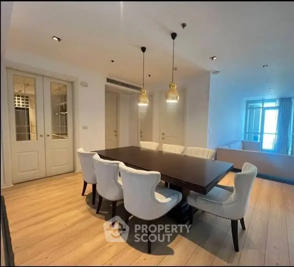 Elegant dining area with modern lighting and stylish seating in a spacious apartment.