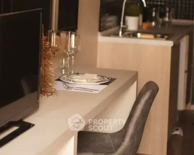 Modern kitchen with sleek design and dining area in open layout apartment.