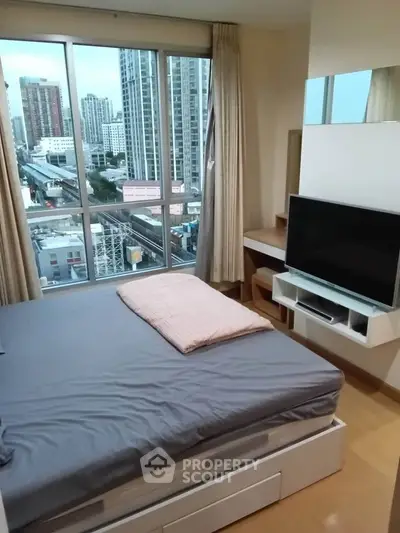 Modern bedroom with city view, featuring a cozy bed, large window, and sleek TV setup.