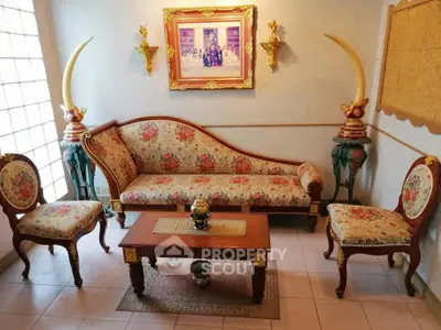 Elegant vintage living room with floral upholstery and classic wooden furniture.