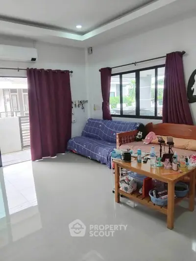 Spacious living room with modern decor and large windows offering natural light.