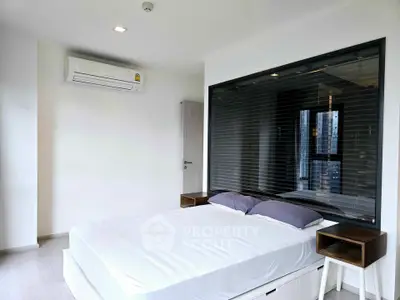 Modern bedroom with large window and air conditioning in a stylish apartment.