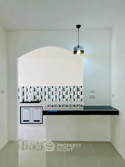 Modern kitchen with sleek design and open layout, featuring stylish backsplash and contemporary lighting.