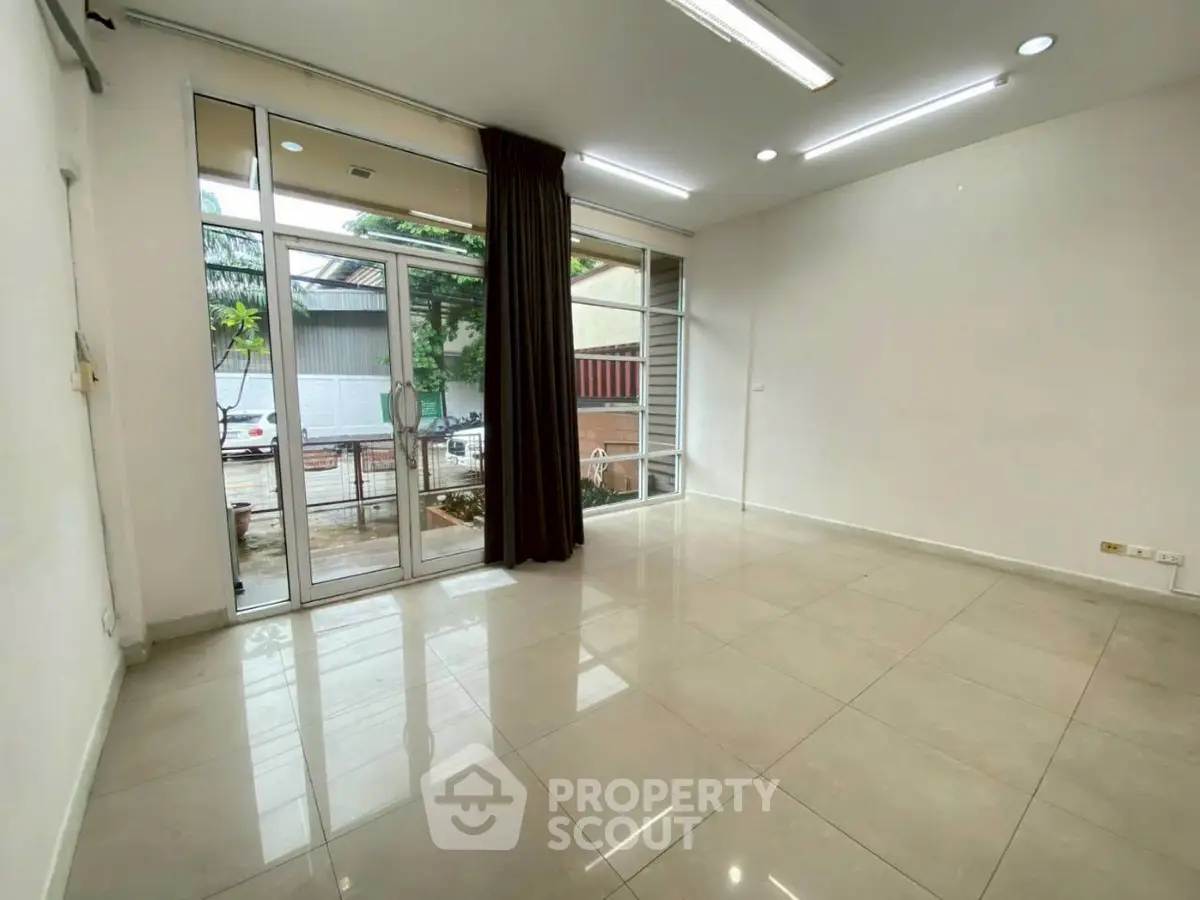 Spacious empty room with large windows and tiled floor, perfect for customization.