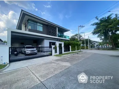 Modern two-story house with spacious driveway and sleek design in a suburban neighborhood.