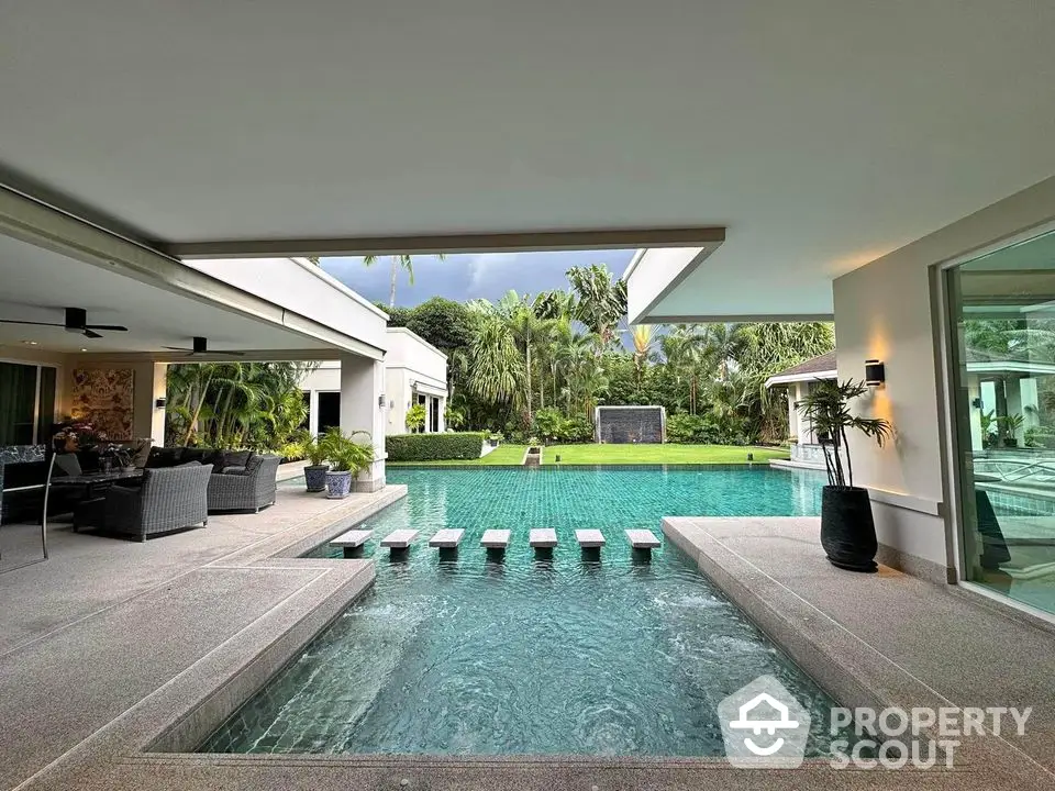 Luxurious modern home with stunning pool and lush garden view.