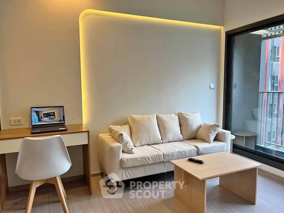 Modern living room with cozy sofa, sleek desk, and balcony view in stylish apartment.
