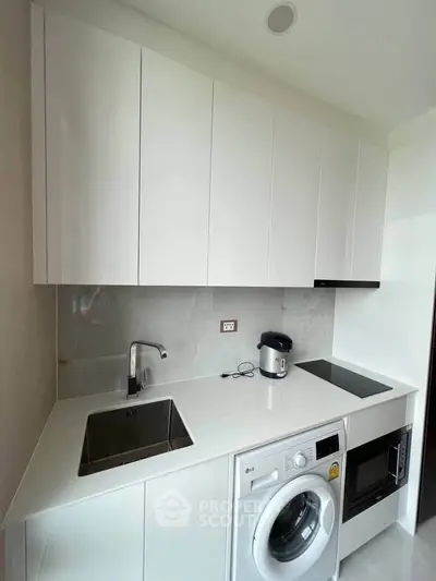 Modern kitchen with sleek white cabinets, integrated appliances, and minimalist design.