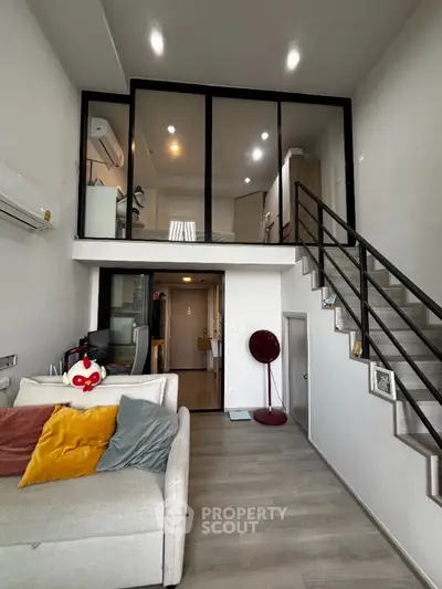 Modern loft apartment with mezzanine, stylish decor, and open layout for urban living.