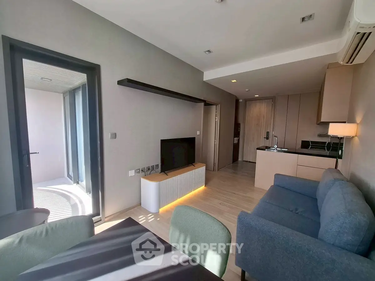 Modern living room with open kitchen and balcony access in stylish apartment