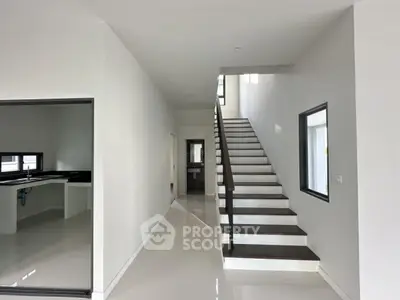 Modern minimalist interior with sleek staircase and open kitchen layout