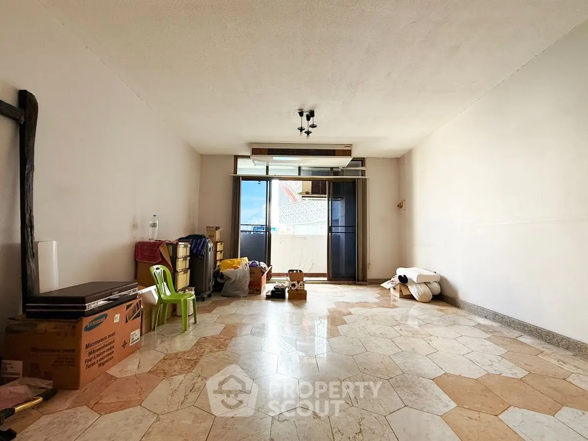 Spacious living room with tiled flooring and balcony access, ideal for customization.