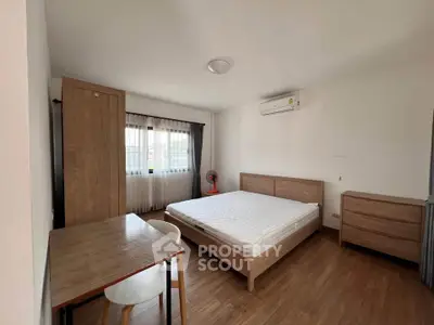 Spacious bedroom with wooden furniture and natural light
