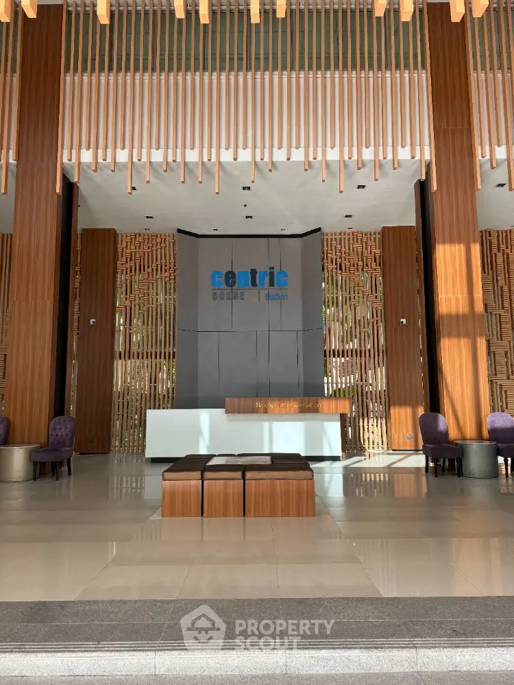 Luxurious modern building entrance with elegant wooden decor and stylish seating area.