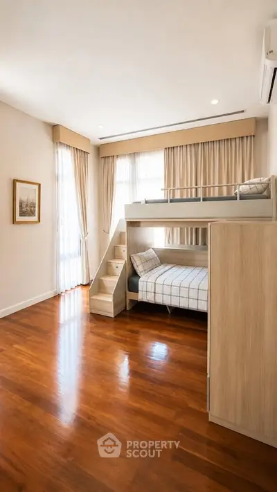 Spacious bedroom with wooden flooring and stylish bunk bed, perfect for modern family living.
