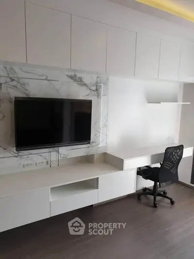 Modern study room with sleek white cabinetry and mounted TV